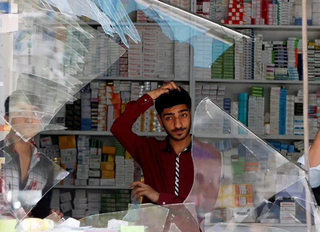 An Afghan shopkeeper reacts behind the broken windows of his shop near the site of a suicide bomb attack in Kabul, Afghanistan on August 29, 2017. (Photo by Omar Sobhani/Reuters)