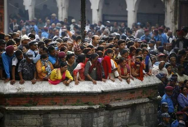 People gather to observe the cremation of Senior Superintendent of Police (SSP) Laxman Neupane, who was killed in Monday's protest at Tikapur in Kailali district, in Kathmandu, Nepal August 25, 2015. (Photo by Navesh Chitrakar/Reuters)