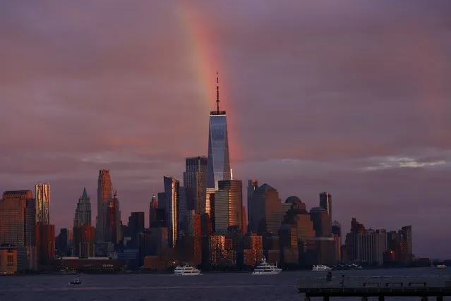 Part of a rainbow rises above the skyline of lower Manhattan and One World Trade Center at sunset in New York City on June 11, 2022, as seen from Hoboken, New Jersey. (Photo by Gary Hershorn/Getty Images)
