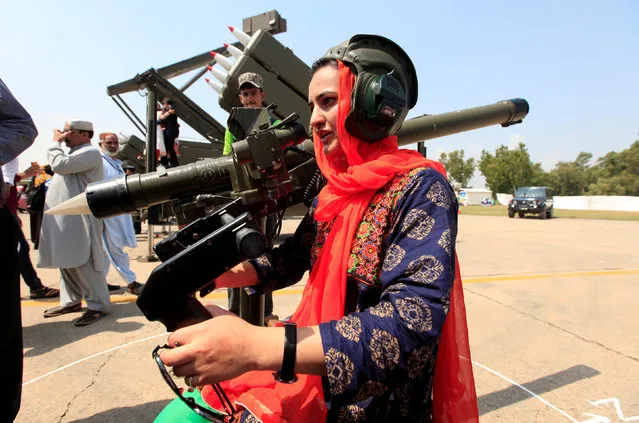 A woman holds on a weapon during a ceremony to commemorate Defence Day, or Pakistan's Memorial Day, at the Nur Khan airbase in Islamabad, Pakistan, September 6, 2017. (Photo by Faisal Mahmood/Reuters)