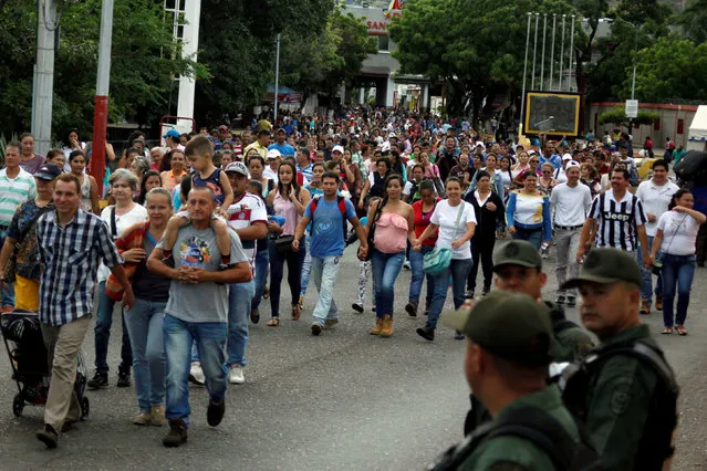 People walk to cross over the Simon Bolivar international bridge to Colombia to take advantage of the temporary border opening in San Antonio del Tachira, Venezuela, July 17, 2016. (Photo by Carlos Eduardo Ramirez/Reuters)