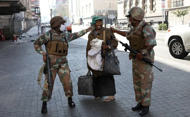 Members of the South African National Defence Force (SANDF) gesture as they speak to a homeless woman during their patrols on the first day of a nationwide lockdown for 21 days to try to contain the coronavirus disease outbreak, in Johannesburg, South Africa, March 27, 2020. (Photo by Siphiwe Sibeko/Reuters)