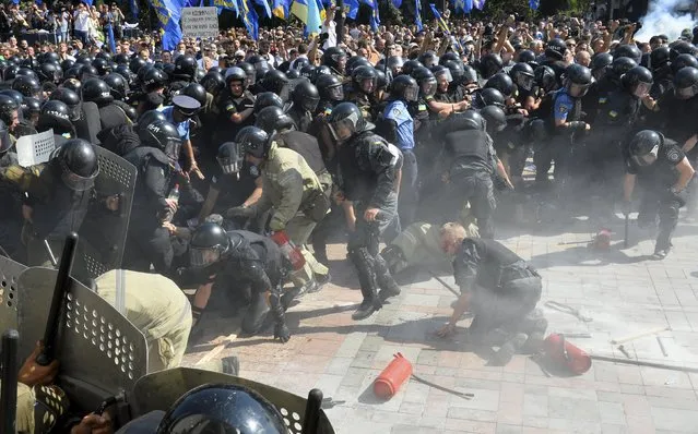 Injured police officers scream in pain as they fall, shortly after an explosion outside the parliament building in Kiev, Ukraine, August 31, 2015. (Photo by Reuters/Stringer)