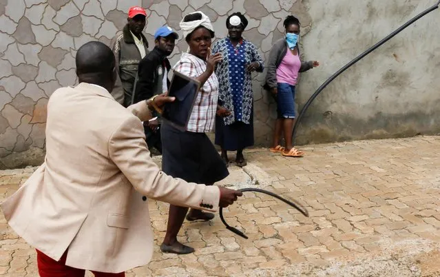 A government official uses a whip in an attempt to disperse civilians who gathered to access relief food rations, amid concerns about the spread of coronavirus in Nairobi, Kenya April 2, 2020. (Photo by Njeri Mwangi/Reuters)