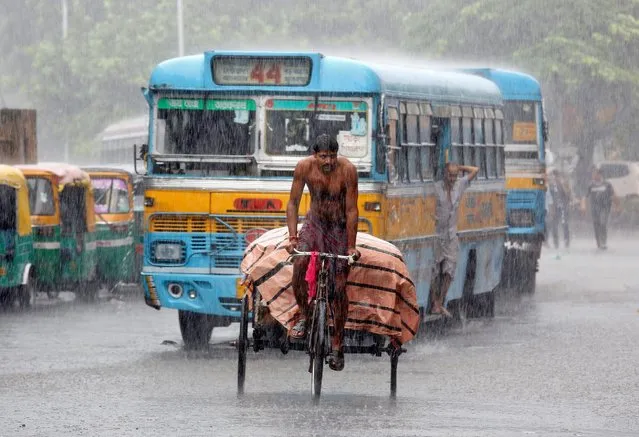 A man paddles his rickshaw on a road during heavy rains in Kolkata, India, July 25, 2016. (Photo by Rupak De Chowdhuri/Reuters)