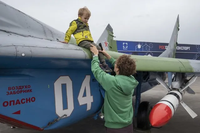 Woman takes her kid out of the MIG-29 fighter jet. Russian international military expo Army Expo 2022 at Patriot park in Kubinka, Moscow, Russia, on August 20, 2022. (Photo for The Washington Post)