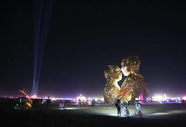 People look at the art installation Embrace during the Burning Man 2014 “Caravansary” arts and music festival in the Black Rock Desert of Nevada, August 27, 2014. (Photo by Jim Urquhart/Reuters)