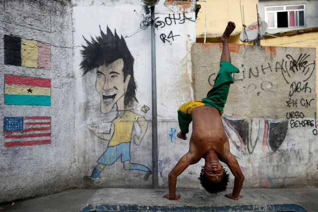 A member of the Acorda Capoeira (Awaken Capoeira) group prepares for a performance for tourists in the Rocinha favela in Rio de Janeiro, Brazil, July 25, 2016. (Photo by Bruno Kelly/Reuters)
