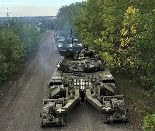 Ukrainian service members ride on tanks during a counteroffensive operation, amid Russia's attack on Ukraine, in Kharkiv region, Ukraine, in this handout picture released September 12, 2022. (Photo by Press service of the General Staff of the Armed Forces of Ukraine/Handout via Reuters)