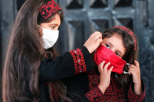 Palestinian girls wearing protective masks attend a graduation ceremony from the Police Academy amid concerns about the spread of the coronavirus COVID-19 in Gaza City on May 7, 2020. (Photo by Mahmud Hams/AFP Photo)
