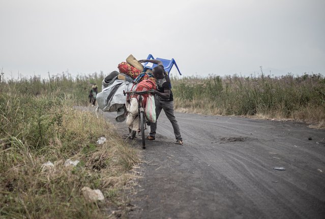 A man, one of the last to evacuates Nzulo, struggles as he pushes his possessions on the back of his bicycle as he leaves the area, near Nzulo, on January 22, 2025. The M23 group which is fighting the Congolese army in eastern Democratic Republic of Congo on January 21, 2025 seized Minova, a trading hub that supplies the city of Goma, security and local sources told AFP. Fighting is now taking place on several fronts around Goma and hundreds of thousands of people are displaced around the outskirts of the city, raising fears again about the city's fate. (Photo by Jospin Mwisha/AFP Photo)