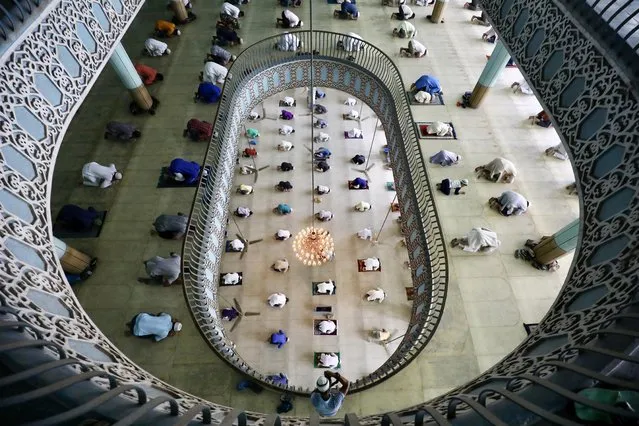 A photographer is seen taking pictures of Friday prayer at the Baitul Mokarram National Mosque after the government has eased the restrictions amid concerns over the coronavirus disease (COVID-19) outbreak in Dhaka, Bangladesh, May 8, 2020. (Photo by Mohammad Ponir Hossain/Reuters)