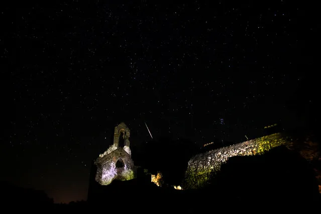A meteor streaks past stars in the night sky above the ruins of a church in the Los Alcornocales (cork oak forests) nature park, during the Perseid meteor shower in the ancient village of La Sauceda, near Cortes de la Frontera, southern Spain, in the early morning of August 12, 2016. (Photo by Jon Nazca/Reuters)