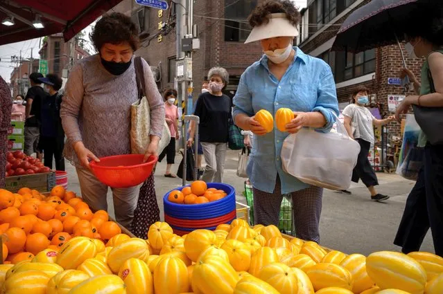 Shoppers walk through a market in Seoul on June 10, 2020. On June 3 the South Korean government proposed its biggest stimulus package yet as it seeks to prop up an economy dragged down by the coronavirus pandemic. (Photo by Ed Jones/AFP Photo)