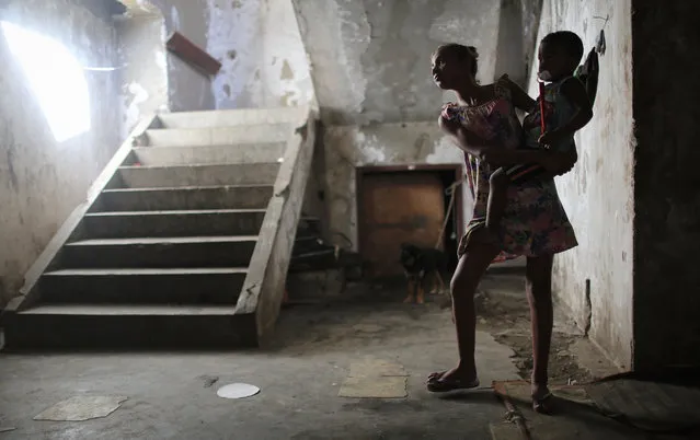 Resident Taina holds her brother Ysaque in the hallway outside their apartment in an occupied building in the Mangueira “favela” community on August 13, 2016 in Rio de Janeiro, Brazil. (Photo by Mario Tama/Getty Images,)