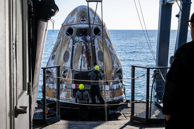 Support teams onboard the SpaceX recovery ship MEGAN work around a SpaceX Dragon spacecraft shortly after it landed with NASA astronauts Nick Hague, Suni Williams, Butch Wilmore, and Roscosmos cosmonaut Aleksandr Gorbunov aboard in the water off the coast of Tallahassee, Florida, Tuesday, March 18, 2025. (Photo by Keegan Barber/NASA/Handout via Reuters)