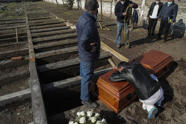 Peruvian migrant Jose Collantes grieves as he cries on the coffin that contains the remains of his wife Silvia Cano, who died due to COVID-19 complications, according to Collantes, at a Catholic cemetery in Santiago, Chile, Friday, July 3, 2020. (Photo by Esteban Felix/AP Photo)