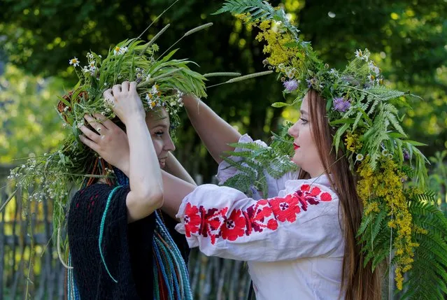 Women wear wreaths as they take part in the Ivan Kupala festival in Belarusian state museum of folk architecture and rural lifestyle near the village Aziarco, Belarus, July 4, 2020. The ancient tradition, originating from pagan times, is usually marked with grand overnight festivities – people sing and dance around campfires, believing it will purge them of their sins and make them healthier. (Photo by Vasily Fedosenko/Reuters)