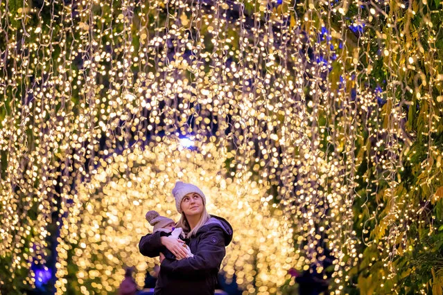 Roxy Dixon, 30 and newborn son Jesse from Leatherhead admire the stunning lights along Wisteria Walk at the launch of “Glow” the Christmas Light trail at RHS Garden Wisley in Surrey last night,  November 17, 2022, running until January. (Photo by Oliver Dixon/RHS)