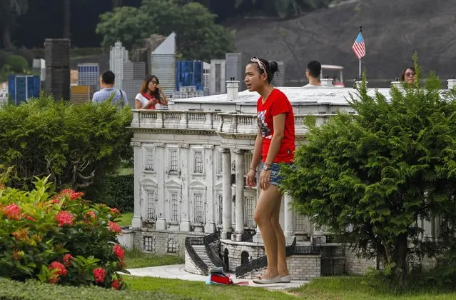 A woman stands next to a miniature replica of the U.S. White House at a theme park called “Window Of The World” in Shenzhen, Guangdong province, October 20, 2014. The park's 48 hectares contain about 130 reproductions of some of the world's most famous tourist attractions. (Photo by Alex Lee/Reuters)