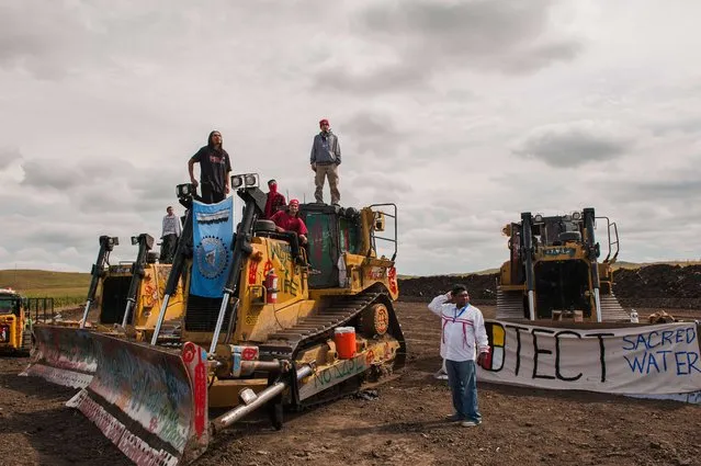 Protesters stand on heavy machinery after halting work on the Energy Transfer Partners Dakota Access oil pipeline near the Standing Rock Sioux reservation near Cannon Ball, North Dakota, U.S. September 6, 2016. (Photo by Andrew Cullen/Reuters)