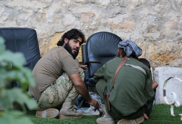 Rebel fighters of al-Jabha al-Shamiya (Levant Front) have their meal in the rebel-held al-Sheikh Said neighbourhood of Aleppo, Syria September 1, 2016. (Photo by Abdalrhman Ismail/Reuters)