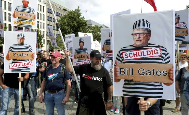 People attend a protest rally in Berlin, Germany, Saturday, August 29, 2020 against new coronavirus restrictions in Germany, holding a sign with Bill Gates in prison clothes, reading “Guilty”. (Photo by Michael Sohn/AP Photo)