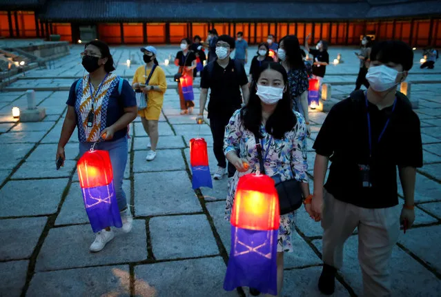 Visitors holding Korean traditional lanterns walk around during the Moonlight Tour at Changdeokgung Palace in Seoul, South Korea, Thursday, August 13, 2020. The palace reopened Thursday after having been closed for two months due to the coronavirus pandemic. (Photo by Kim Hong-Ji/Reuters)
