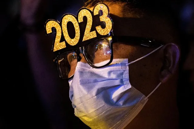 A man attends a New Year's Eve party wearing glasses with the year 2023, in Quezon City, Metro Manila, Philippines, December 31, 2022. (Photo by Eloisa Lopez/Reuters)