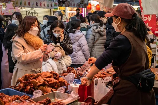 People shop for food ahead of the New Year holiday in Tokyo on December 29, 2022. (Photo by Yuichi Yamazaki/AFP Photo)
