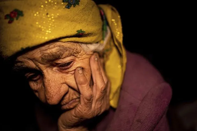 Nina Gonchar, 93, sits in her house which was mostly destroyed by Russian forces in the recently retaken village of Bogorodychne, Ukraine, Saturday, January 7, 2023. Gonchar's son Vasyliy and his wife Liubov were killed by Russian shelling on July 10, 2022. (Photo by Evgeniy Maloletka/AP Photo)