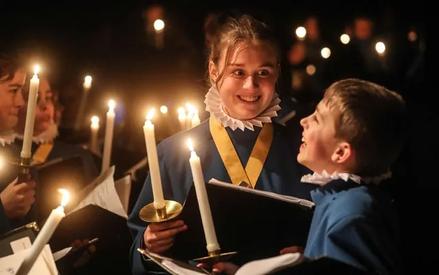 Candles are lit in preparation for the annual Candlelight Christmas Concert at Wells Cathedral in Somerset on December 20, 2022. The highly popular concert contains 3,500 candles, over 3 nights, a total of 10,500 candles will be used. The Candles are 1.5 inches long and last for 6 hours, Team of 16 taking 3 hours to light them each night. (Photo by Jason Bryant/Apex News)