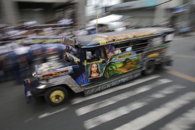 In this October 16, 2017, photo, a passenger jeepney with a painting of Jesus Christ travels along a road in Manila, Philippines. (Photo by Aaron Favila/AP Photo)