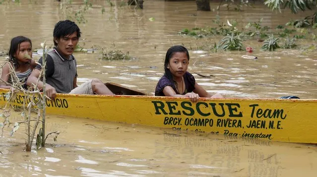 Typhoon victims ride on a rescue boat along a flooded road in Jaen, Nueva Ecija in northern Philippines October 20, 2015, after the province was hit by Typhoon Koppu. (Photo by Erik De Castro/Reuters)