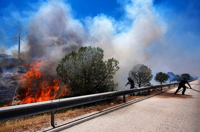 Firefighting efforts continue after a wildfire broke out in an agricultural area and spread to nearby forests in Cesme district of Izmir, Turkiye, on July 3, 2025. Two planes, six helicopters and ground teams are continuing their efforts to combat the fire in the Cesme district. (Photo by Berkan Cetin/Anadolu via Getty Images)