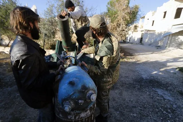Fighters from the Noureddine Zanki movement, which operates under the Free Syrian Army, prepare an improvised explosive to fire towards forces loyal to Syria's President Bashar al-Assad at the frontline in Aleppo's al-Rashideen neighborhood November 27, 2014. (Photo by Hosam Katan/Reuters)