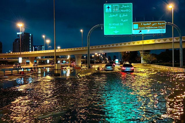 Motorisits drive along a flooded street following heavy rains in Dubai early on April 17, 2024. Dubai, the Middle East's financial centre, has been paralysed by the torrential rain that caused floods across the UAE and Bahrain and left 18 dead in Oman on April 14 and 15. (Photo by Giuseppe Cacace/AFP Photo)