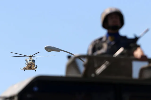 A Cypriot soldier sits atop an armoured vehicle while a helicopter flies above during  a military parade marking Cyprus' Independence Day in Nicosia, Cyprus October 1, 2016. (Photo by Yiannis Kourtoglou/Reuters)