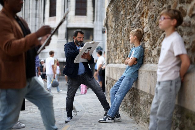 Artists create portraits of tourists on the street in Montmartre, Paris, France on July 29, 2025. (Photo by Tom Nicholson/Reuters)