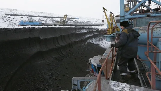 Machinist Sergei Klushnichenko stand onboard a rotary dredge which works on the coal face of the Borodinsky opencast colliery, near the Siberian town of Borodino, east of Krasnoyarsk, December 9, 2014. (Photo by Ilya Naymushin/Reuters)