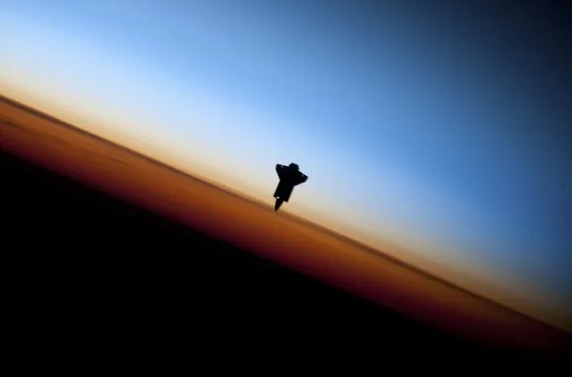 The space shuttle Endeavour silhouetted against the backdrop of Earth's horizon prior to docking with the International Space Station on February 9, 2010. (Photo by Reuters/NASA)