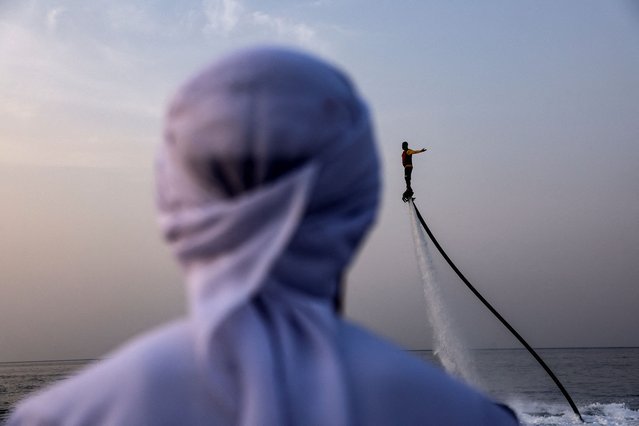 A man watches another man on a flyboard during a water show in Musandam, Oman on August 27, 2025. (Photo by Amr Alfiky/Reuters)