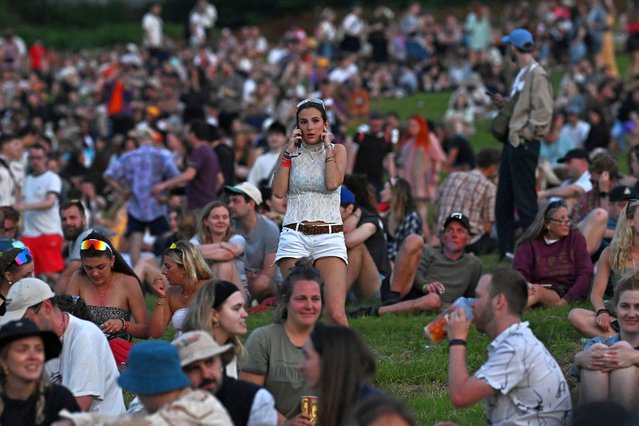 Revellers watch as the sun set at Worthy Farm in Pilton, Somerset for the Glastonbury Festival, Britain, on June 26, 2024. (Photo by Dylan Martinez/Reuters)