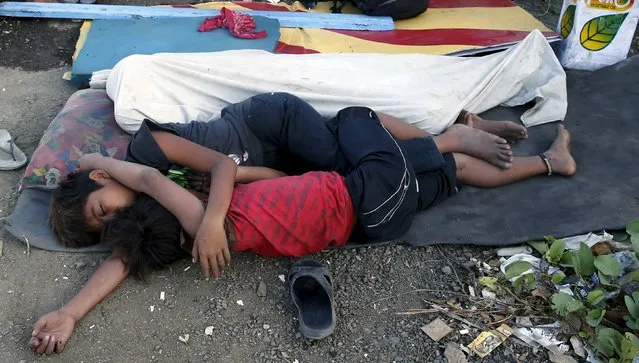 Homeless people sleep on a vacant lot near the venues of the Asia-Pacific Economic Cooperation (APEC) summit, which will be held next week, during a security preparation in Manila November 14, 2015. (Photo by Erik De Castro/Reuters)