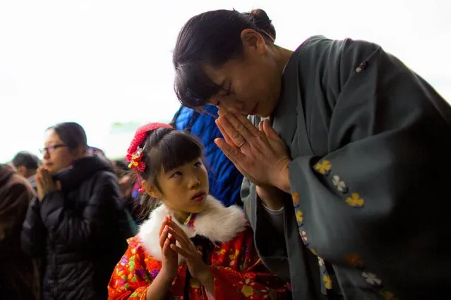 A woman and a girl in kimonos pray on the first day of the New Year at the Shinto Meiji Shrine in Tokyo January 1, 2015. (Photo by Thomas Peter/Reuters)