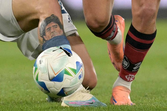 This detailed view shows the tattoo of Argentine football legend Diego Maradona on the leg of Racing's defender #27 Gabriel Rojas as he fights for the ball against Flamengo's Uruguayan midfielder #10 Giorgian de Arrascaeta during the Copa Libertadores semifinal second leg football match between Argentina's Racing and Brazil's Flamengo at the Presidente Juan Domingo Peron - El Cilindro stadium in Avellaneda, Buenos Aires province, on October 29, 2025. (Photo by Juan Mabromata/AFP Photo)