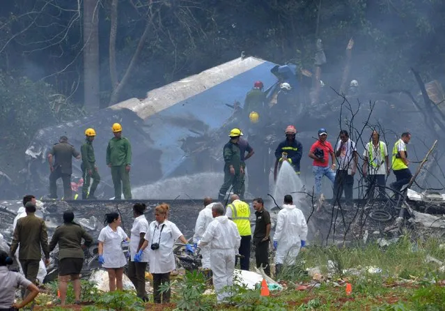 Picture taken at the scene of the accident after a Cubana de Aviacion aircraft crashed after taking off from Havana's Jose Marti airport on May 18, 2018. A Cuban state airways passenger plane with 104 passengers on board crashed on shortly after taking off from Havana's airport, state media reported. The Boeing 737 operated by Cubana de Aviacion crashed “near the international airport”, state agency Prensa Latina reported. Airport sources said the jetliner was heading from the capital to the eastern city of Holguin. (Photo by Adalberto Roque/AFP Photo)