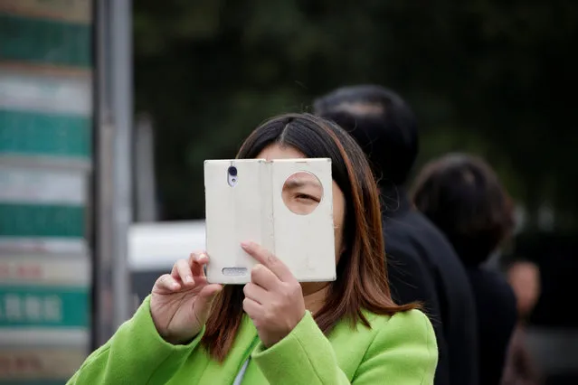 A woman takes a picture from her mobile phone near Tiananmen Square, in Beijing, China, October 24, 2016. (Photo by Jason Lee/Reuters)