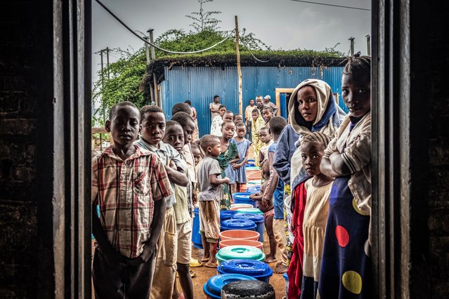 Refugees from eastern Democratic Republic of the Congo, newly arrived after renewed fighting broke out, line up with buckets at a food distribution point at Nyarushishi Transit Camp in Rusizi district on December 11, 2025. Congolese refugees described neighbours being massacred and losing children in the chaos as they fled into Rwanda to escape a surge in fighting despite a peace deal brokered by US President Donald Trump.Around 1,000 Congolese have ended up in Nyarushishi refugee camp in Rwanda's Rusizi district after renewed fighting broke out in eastern Democratic Republic of Congo earlier this month. The M23 armed group, backed by Rwanda, has seized vast swathes of eastern DRC over the past year and is once again on the march, taking another key city of Uvira in recent days. (Photo by Vivien Latour/AFP Photo)