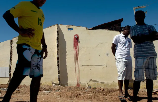 A miniature football pinned to a wall with red paint symbolizing blood is seen in Fortaleza, Northeastern Brazil, on June 19, 2013 during a protest of what is now called the “Tropical Spring” against corruption and price hikes. In a country with one of the widest income disparities in the world – billions of dollars were being spent on stadiums and little on social programs – and the Confederations Cup football tournament going on, Brazil has two weeks to convince sceptics that it can honour its pledge to stage a successful World Cup in 2014. (Photo by Yuri Cortez/AFP Photo)